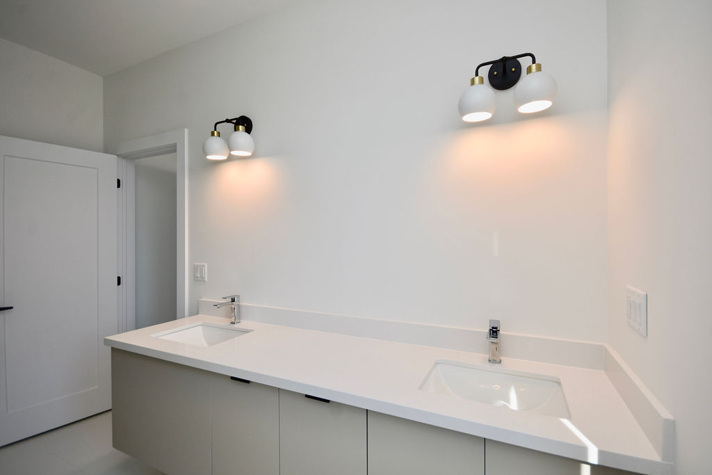 Ensuite bathroom's double sink vanity with sconce lighting.